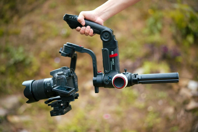 a person holding a camera with a tripod on the back