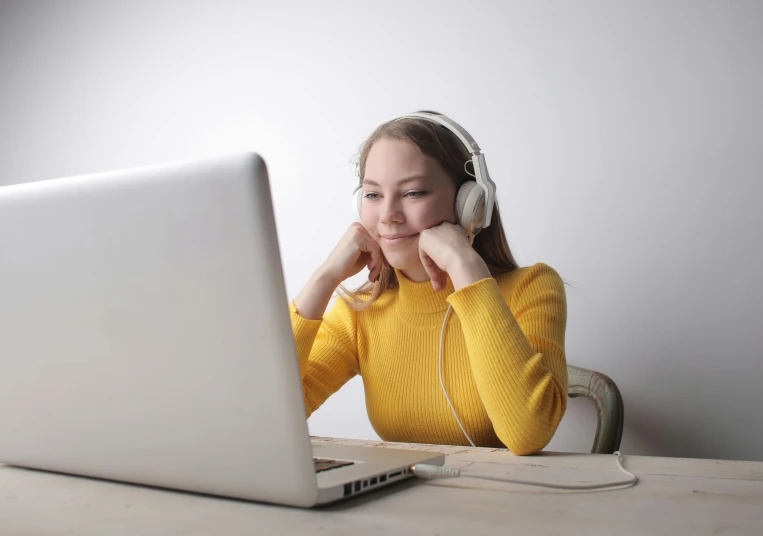 a girl is listening to music on her computer