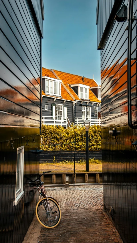 a bicycle leans against a black fence near a house