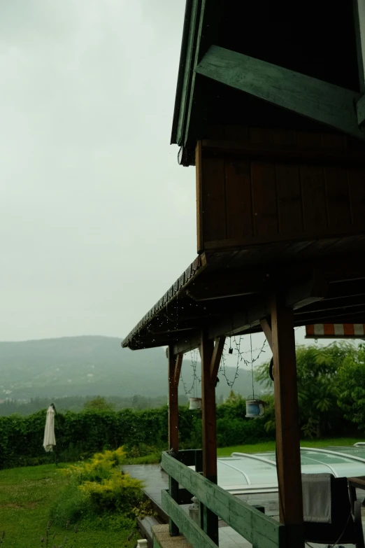 a bird stands on the railing as it is raining