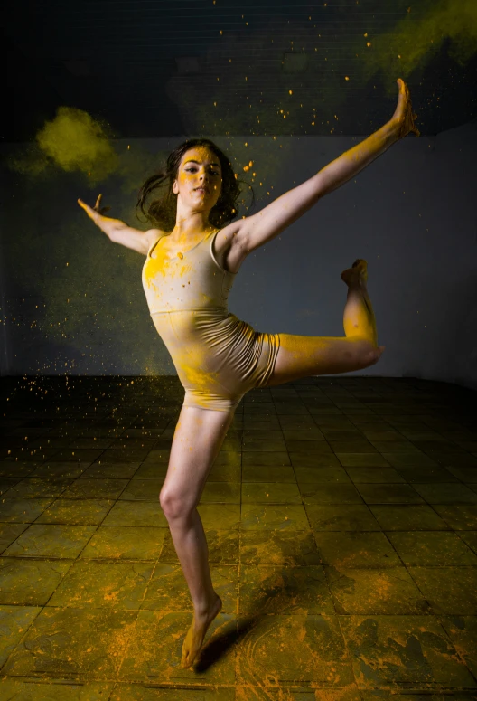 a woman doing a dancing pose while covered in powder