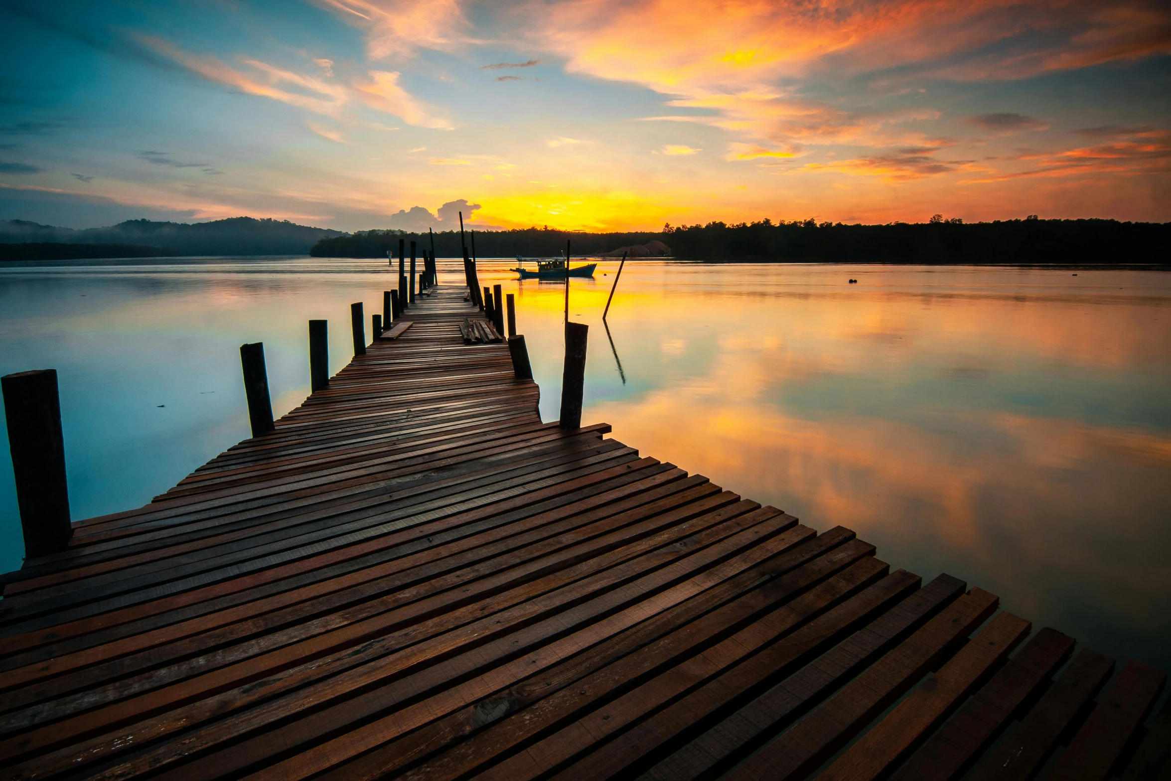 a sunset on the river with wooden dock