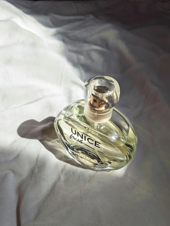 a bottle of perfume sitting on a white sheet