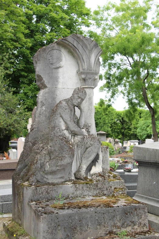 statue sitting on concrete slab with trees in background