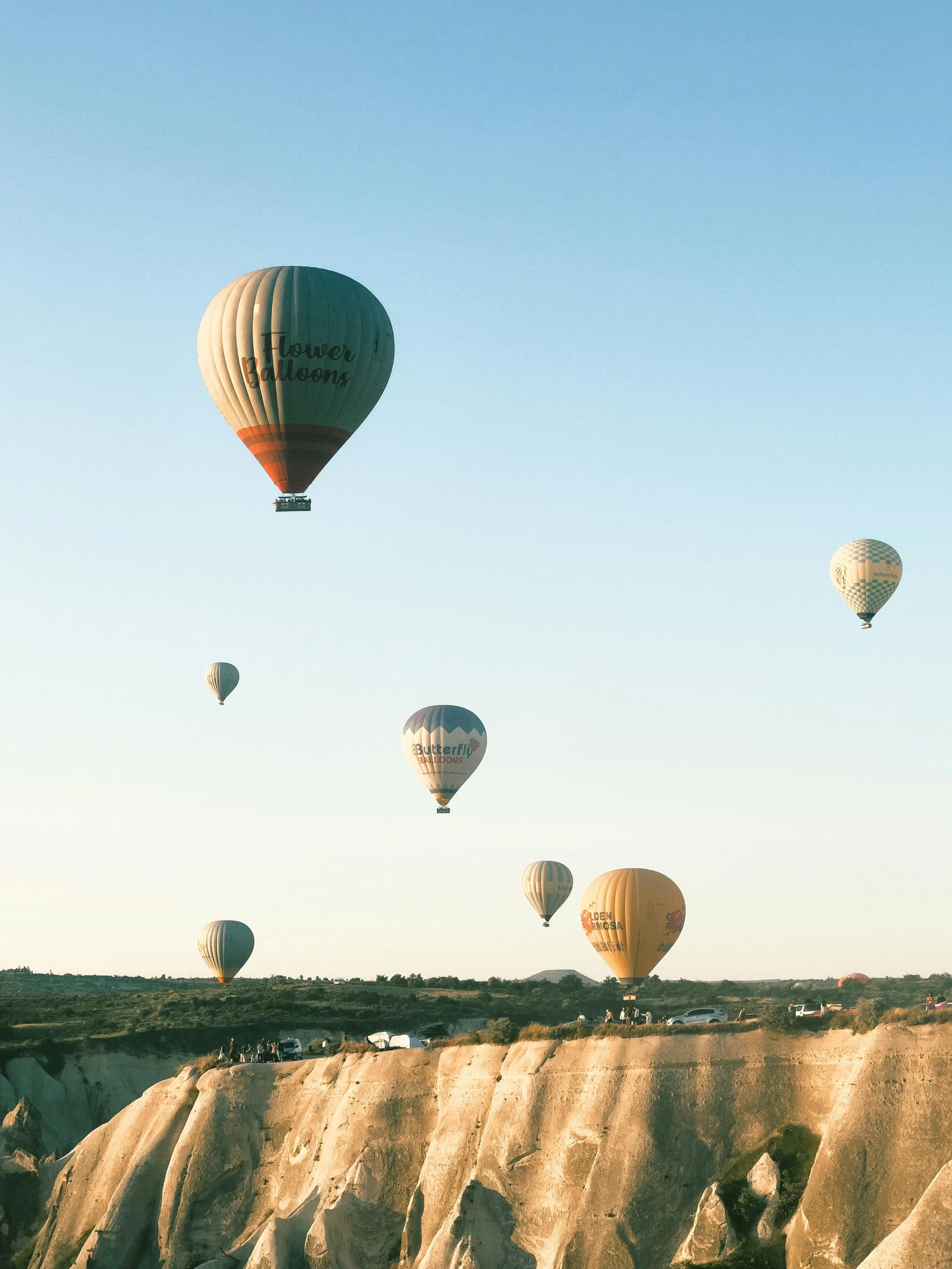 the air balloons are flying over the sand hills