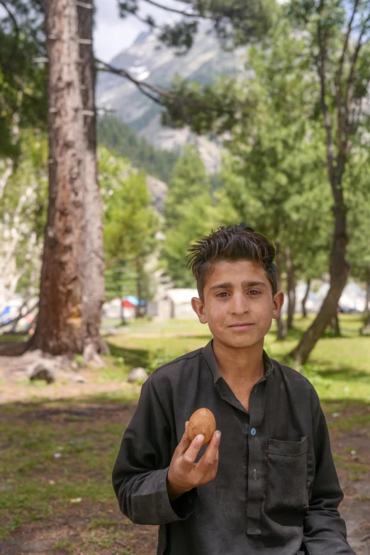 a man sitting on a rock holding food in his hand