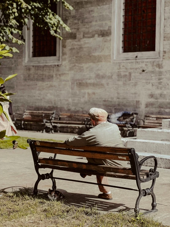 a person sitting on a park bench in front of a building