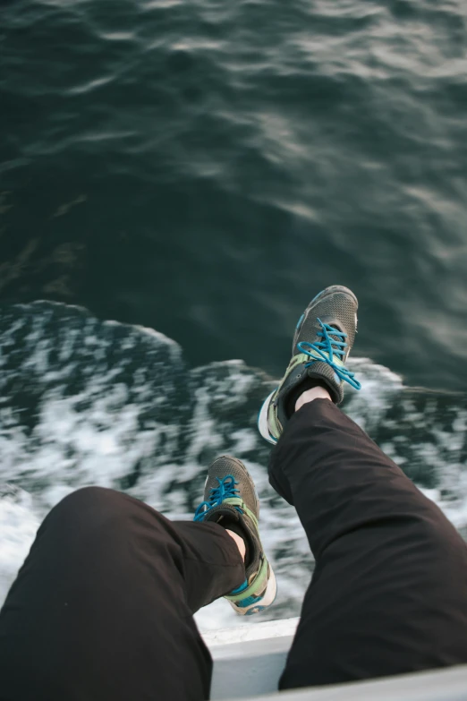 person with legs crossed sitting on boat in open water