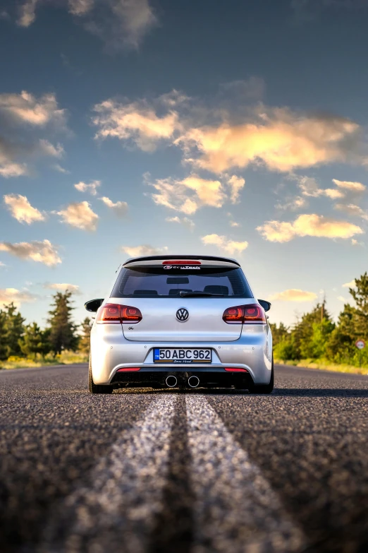 car parked in the middle of a road with the sun shining