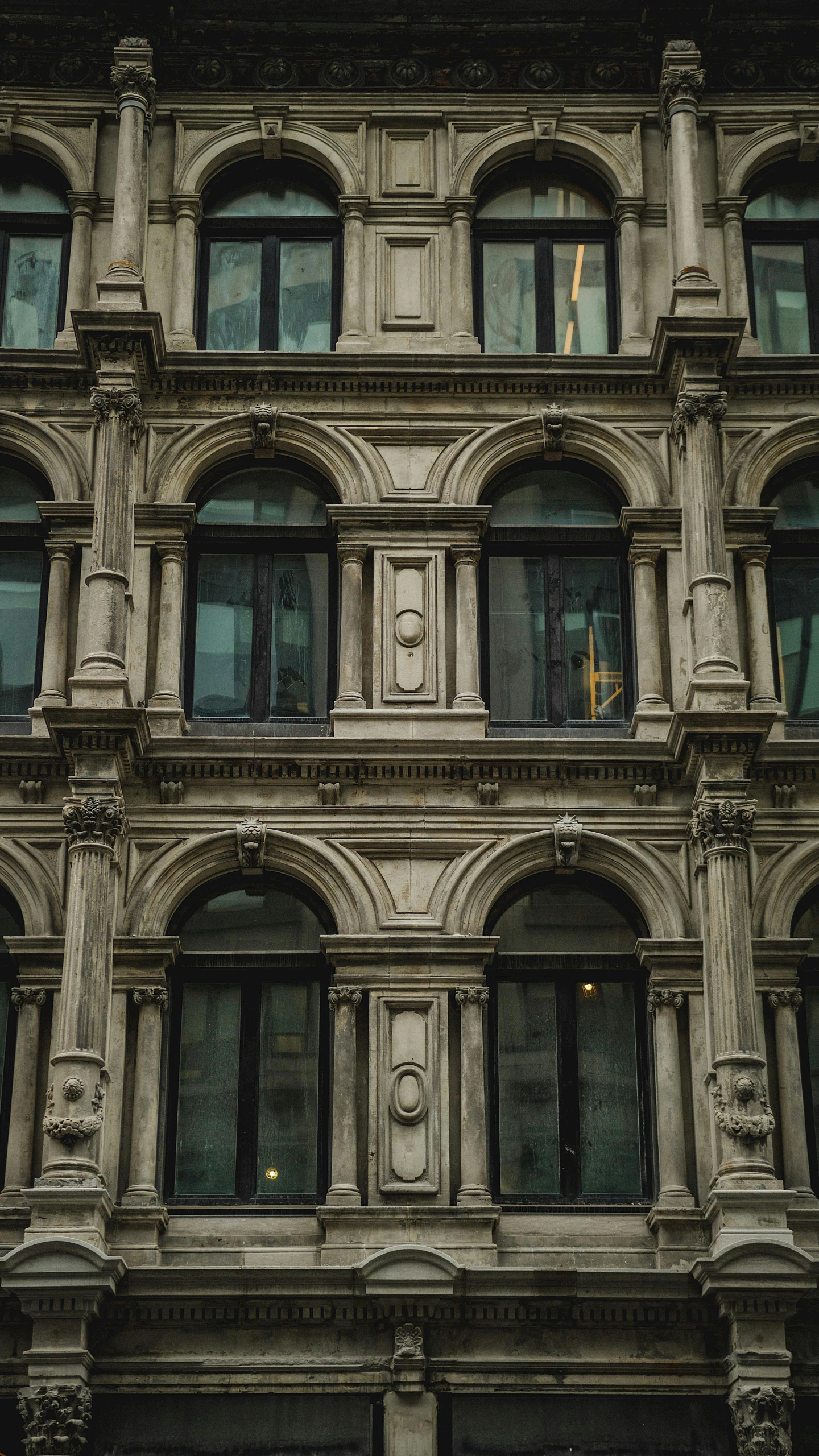 a building with ornate windows that has an iron fence