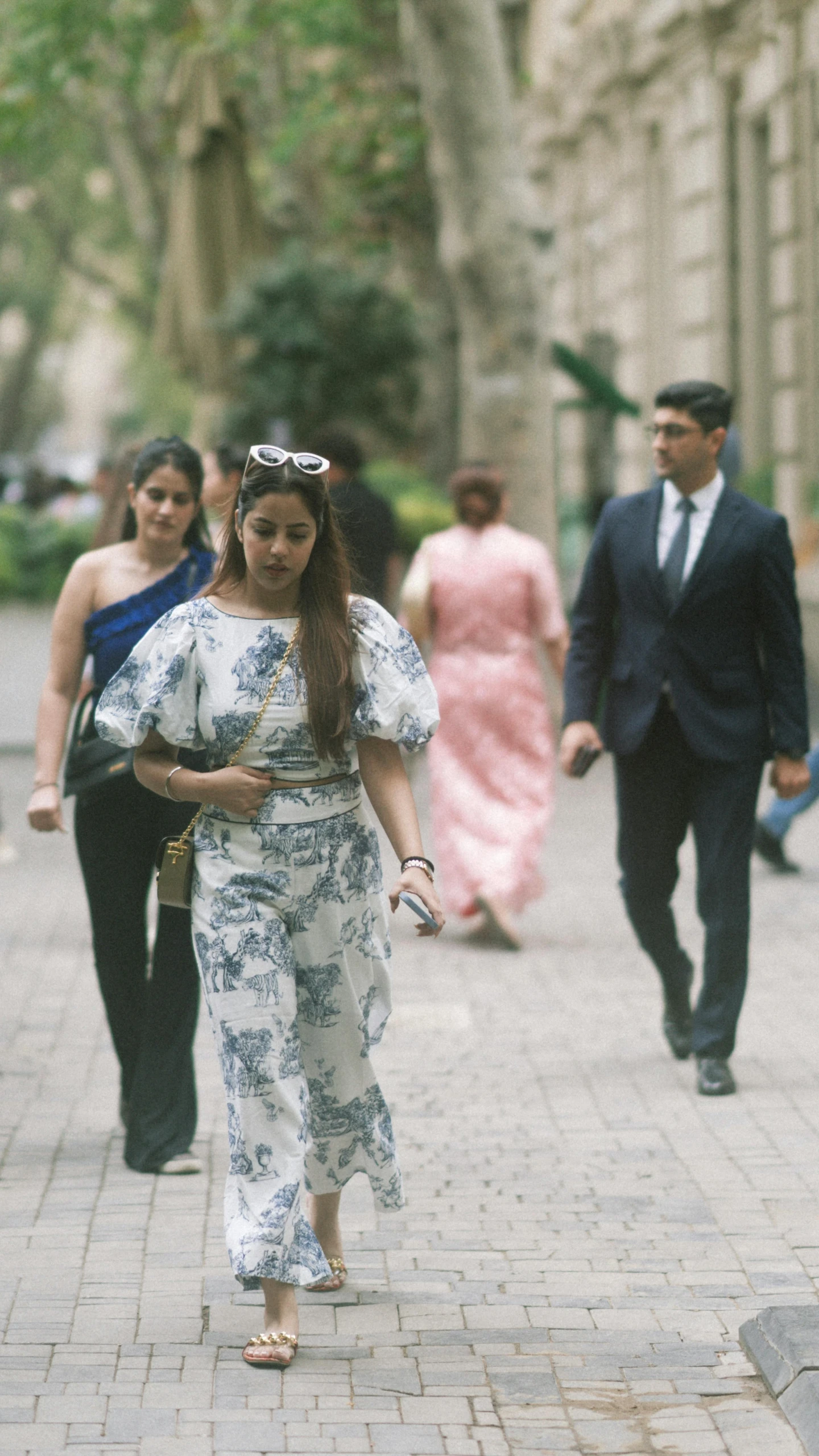 people walking down a street on tiled stone ground