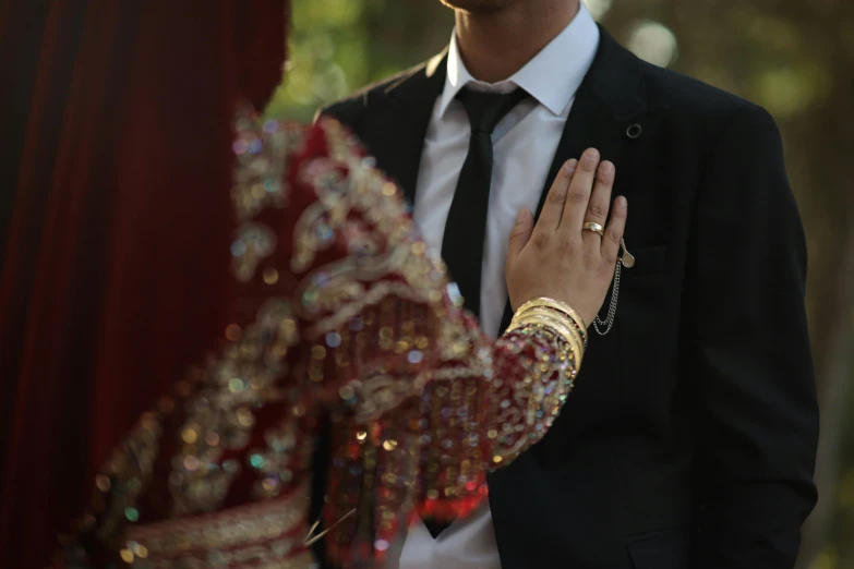 a man standing next to another wearing a suit