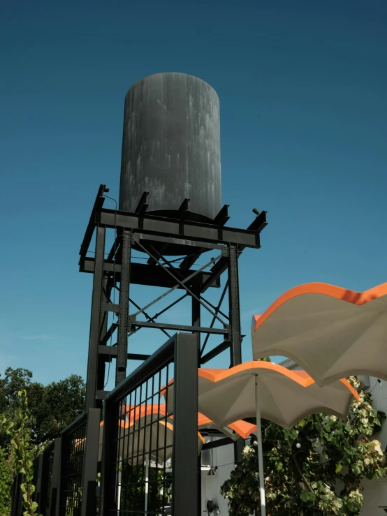 there are umbrellas on the ground and a large water tower behind