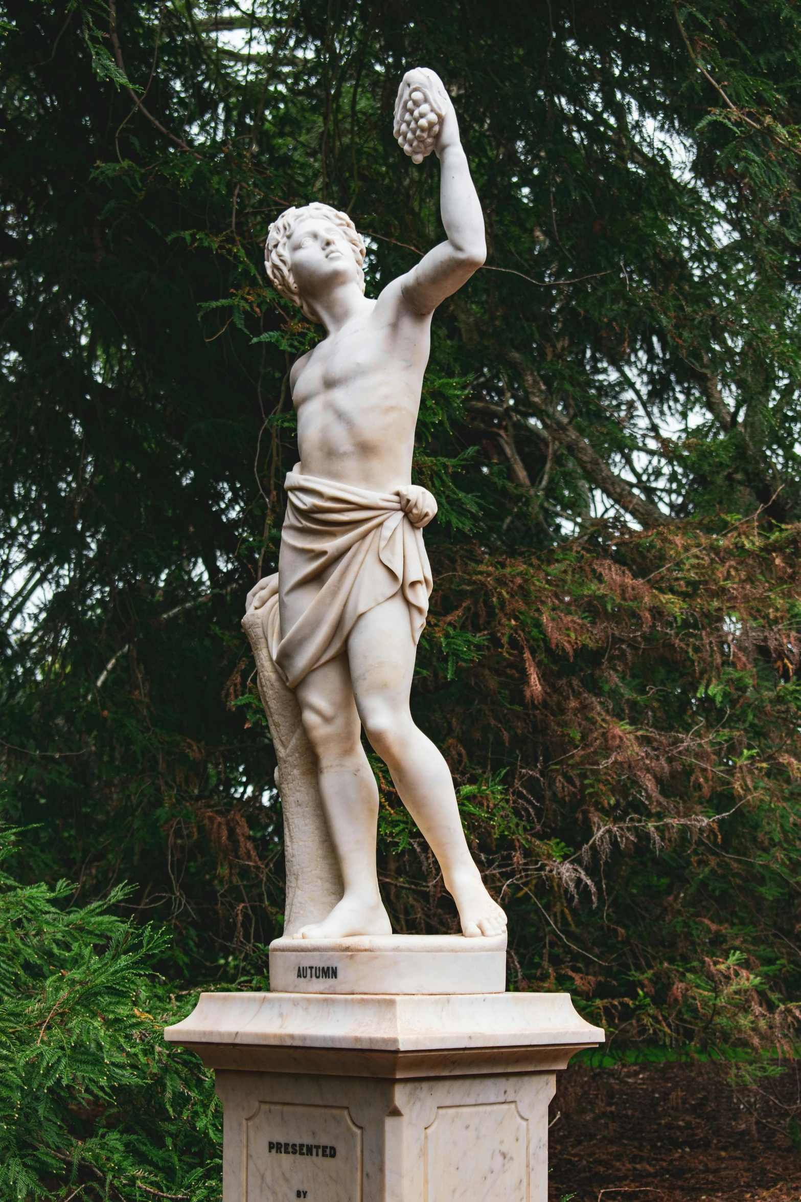 a statue of a young man holding an apple