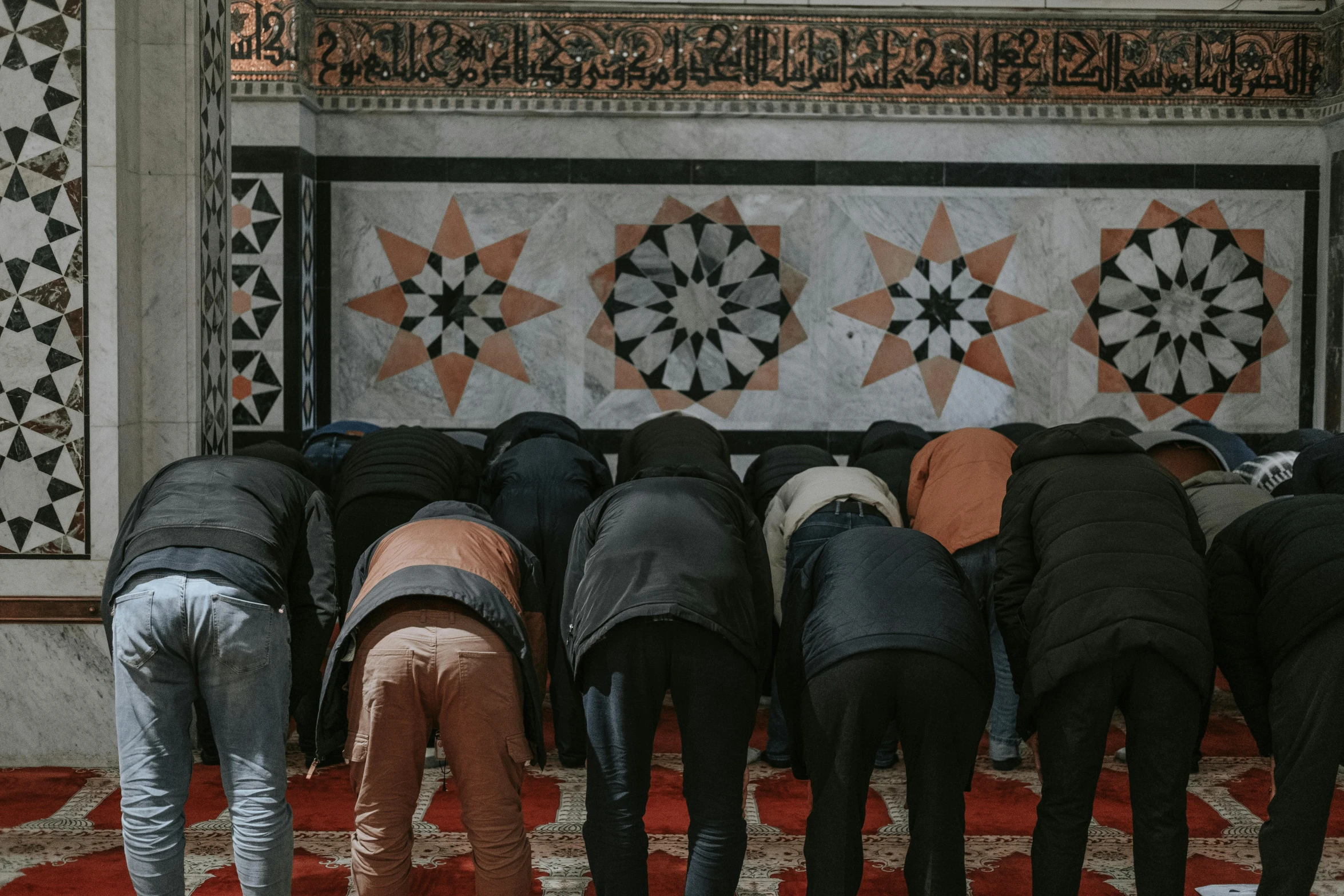 men praying in a mosque decorated with large ornaments