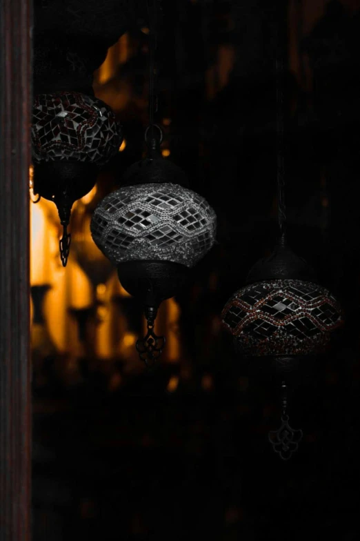 some hanging lamps that are lit up in the dark