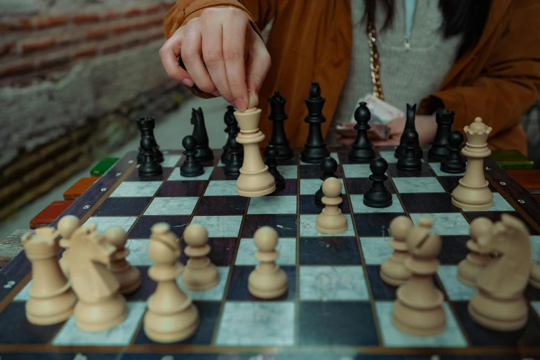 a lady is playing a game of chess