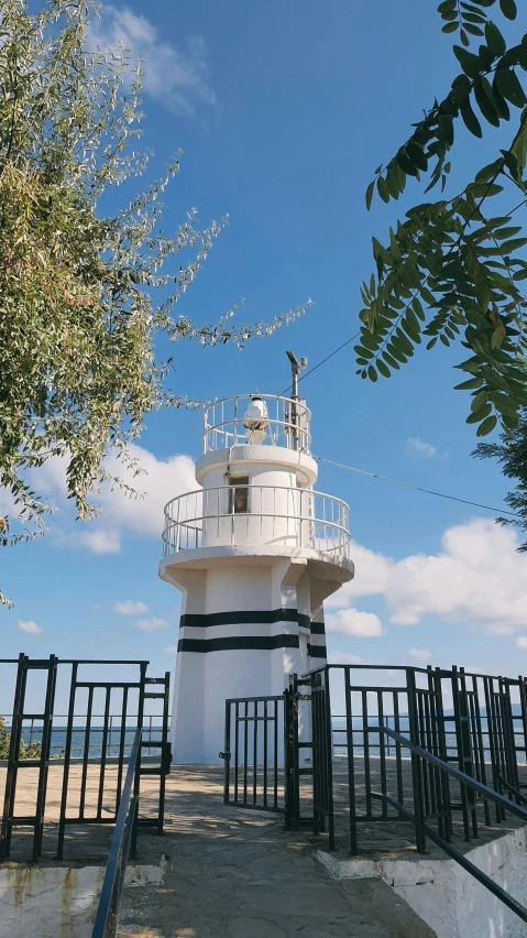 a white lighthouse sitting on top of a hill