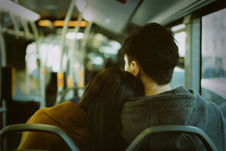 a couple sits on the bus looking at the street