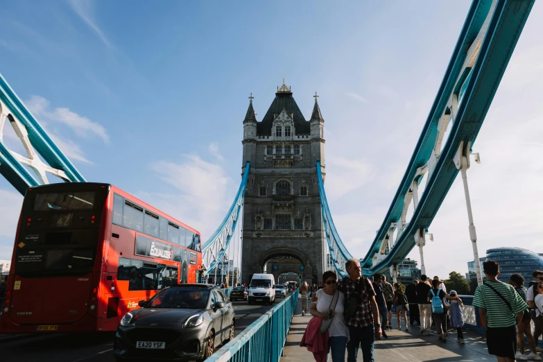 people are walking across the bridge near traffic