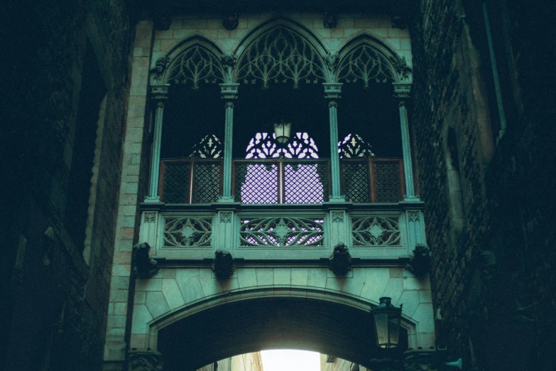 view down the walkway below a gate on the bridge