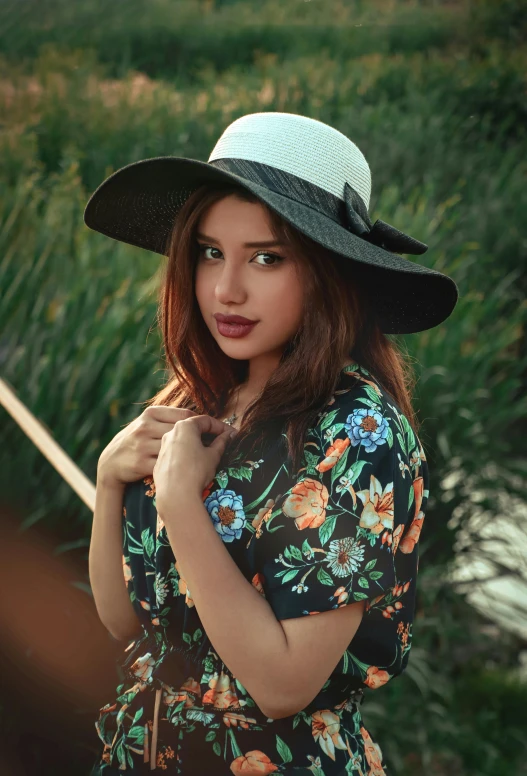 a woman in a hat with flowers posing for a po