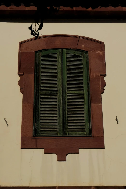 an open window with shutters on top of it