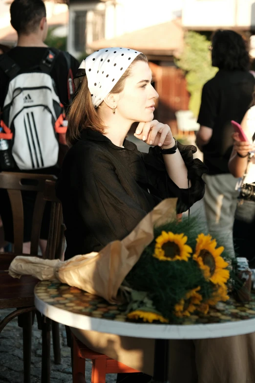 a woman sitting at a table with a white headband on
