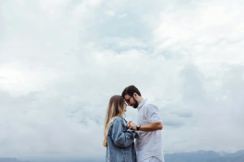 a couple with sunglasses on emcing on a cloudy day