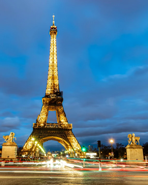 the eiffel tower, light shows as it crosses the street