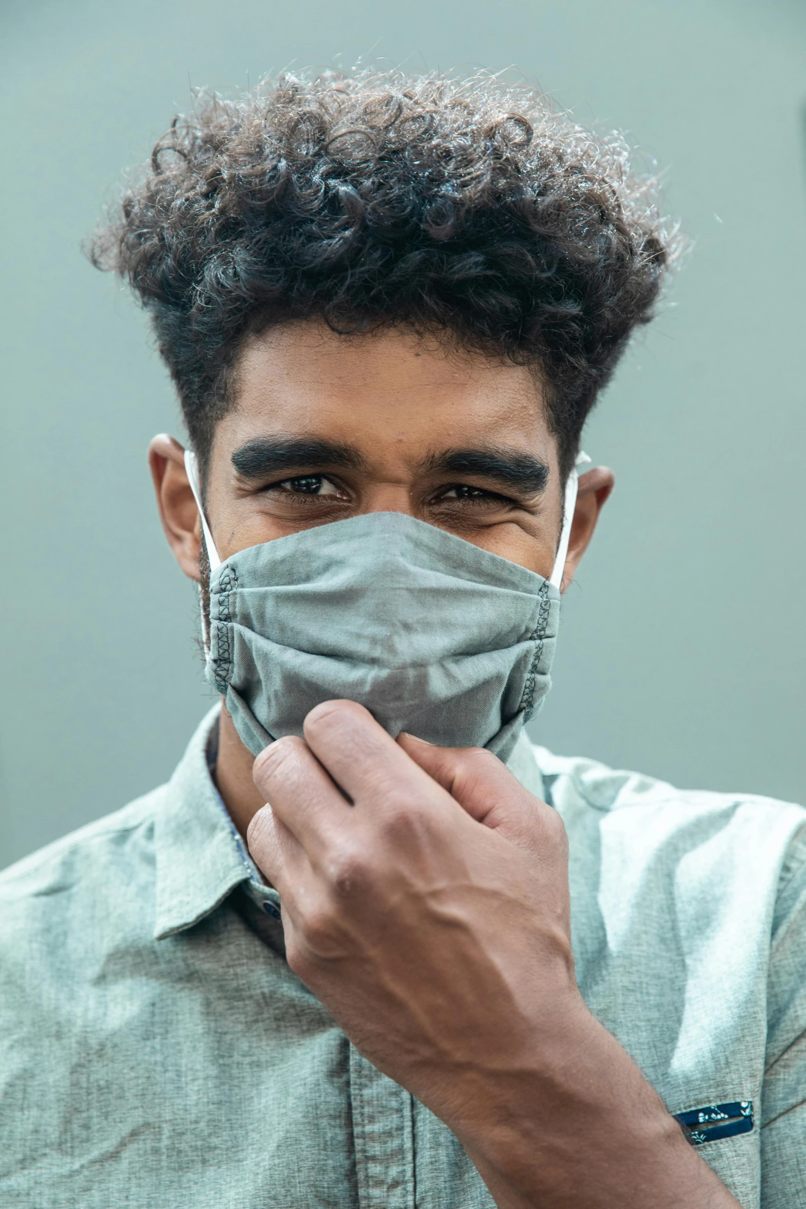 a man with a face mask on holding onto his hands