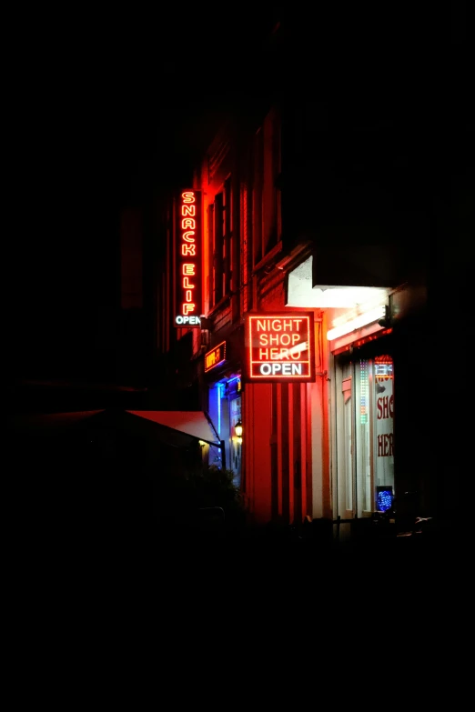 the building is lit up and it has signs on the front