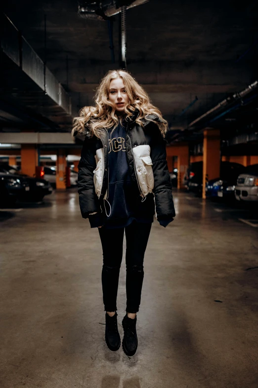 woman in coat walking through parking garage in urban setting