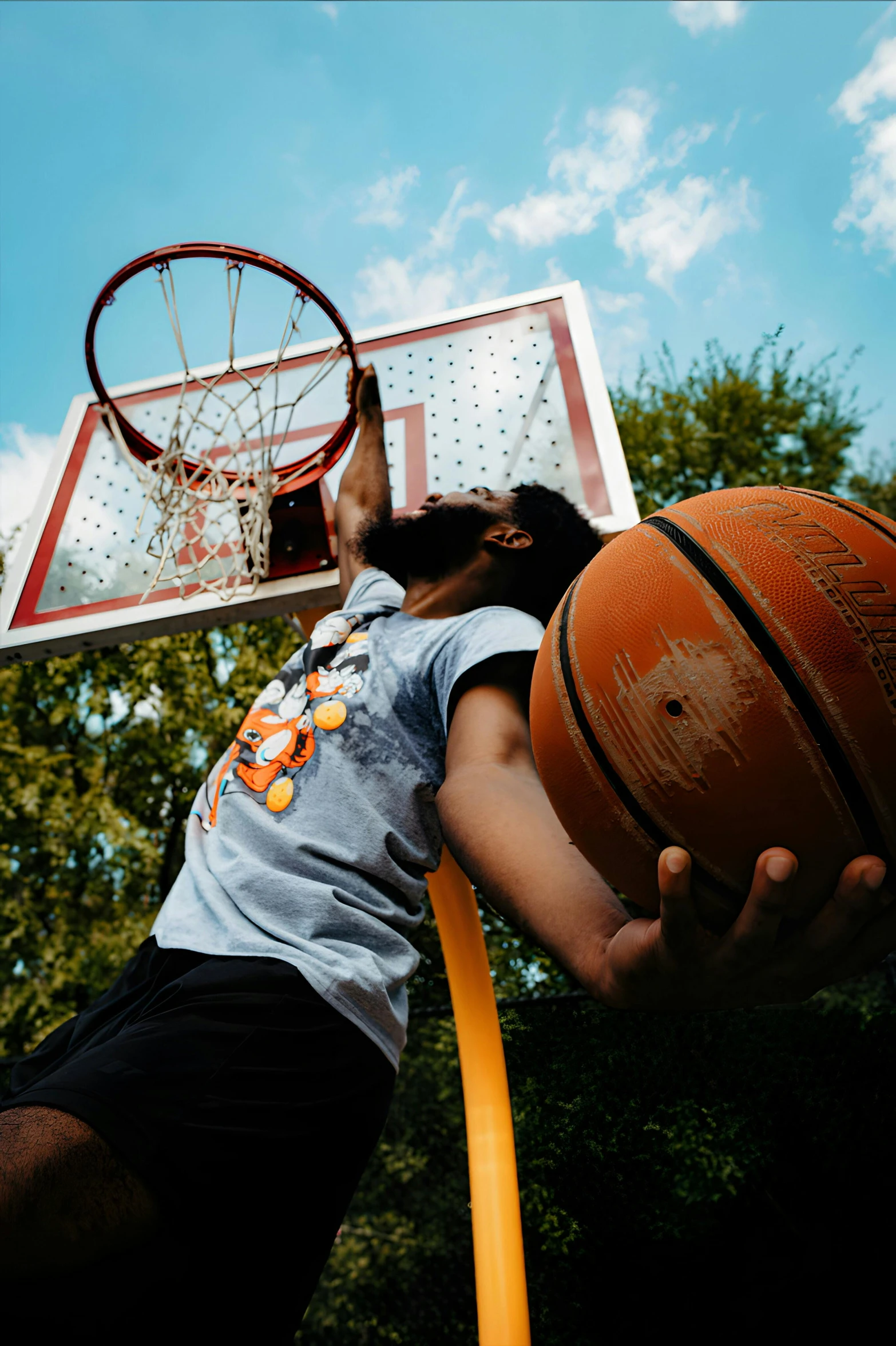 a person holding a basketball near a hoop