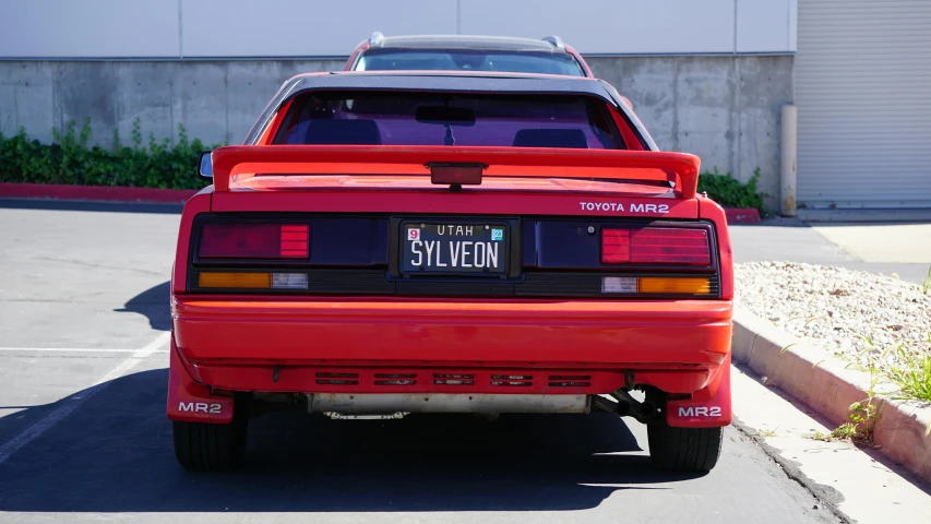 red sports utility car parked in lot with city name plate