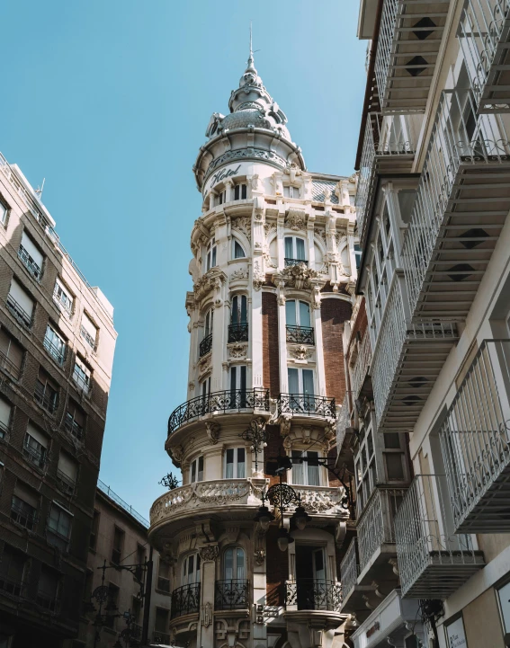 a tall building sitting between two buildings with balconies