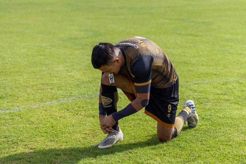 the soccer player is squatting down for the ball