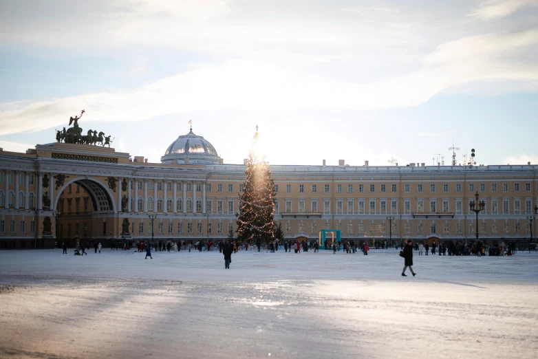 a very large ornate building with people in the snow in front of it