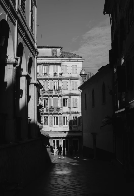 this is an old po of a cobblestone street with people standing in it