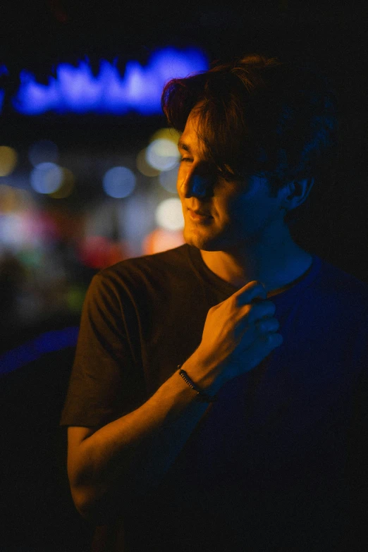 young man standing with his hands crossed at night