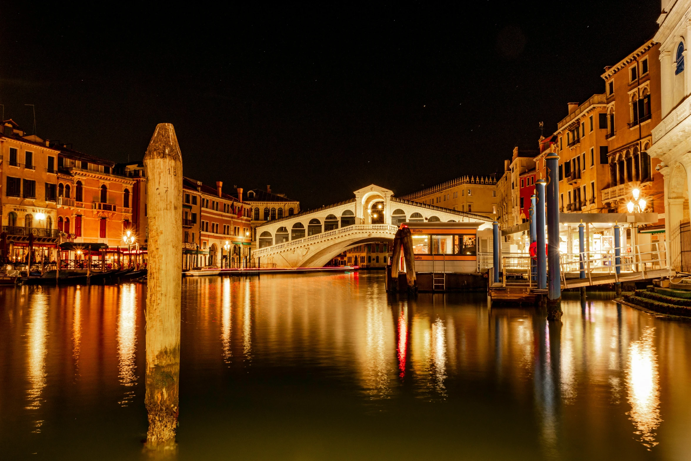 the lights on a bridge reflect in the water