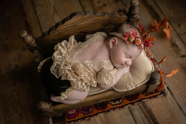 baby girl sleeping in a rocking chair wearing a lacy diaper