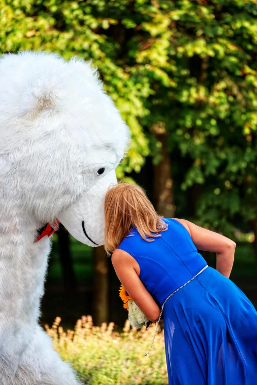 a young child is kissing a large polar bear