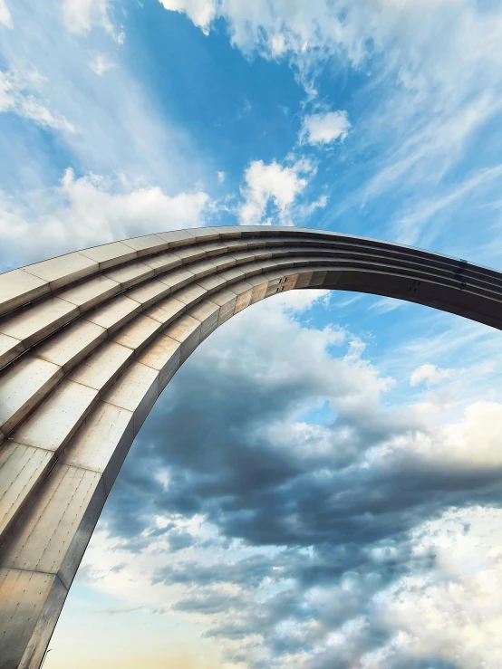 an arch leading to a sky filled with clouds