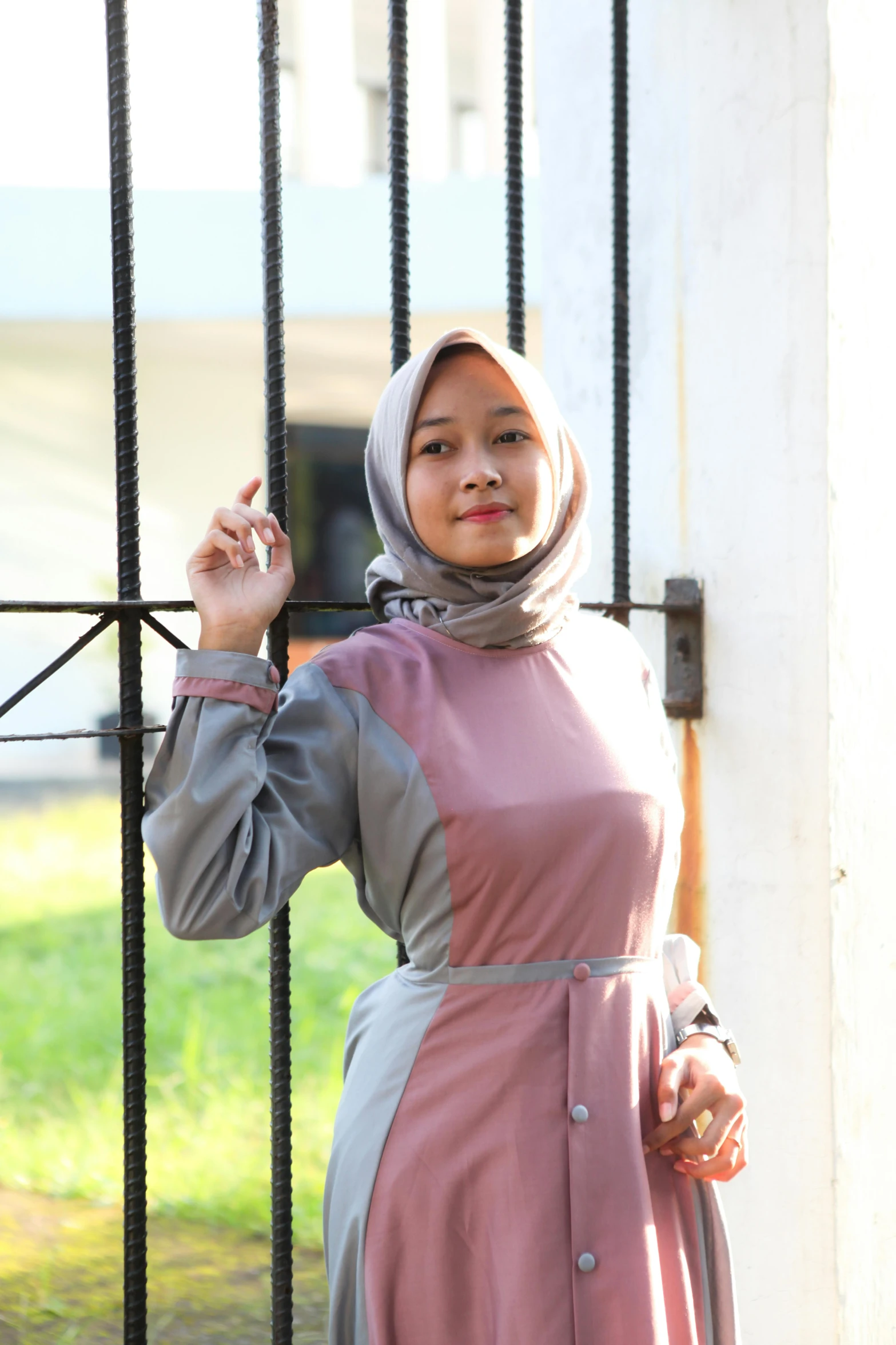 a woman is standing near a gate