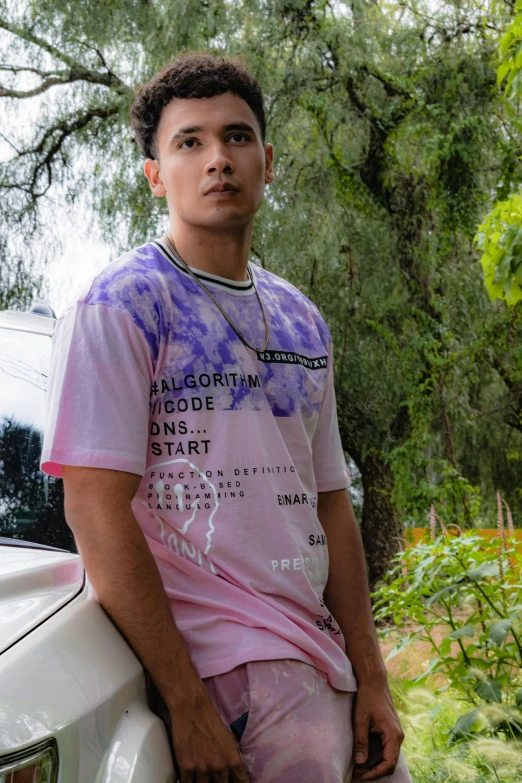 a man sitting next to his car and trees