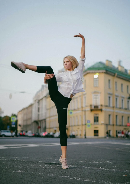 a woman is performing an aerial trick in the street