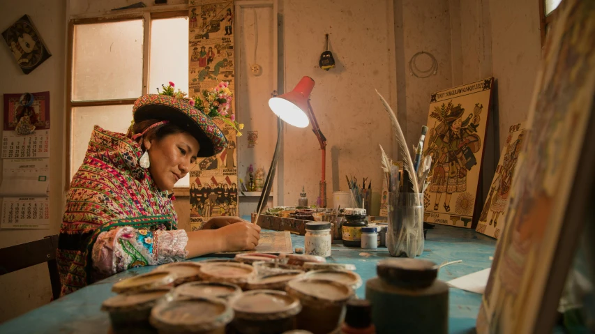 a lady sits at a table in a room that contains jars and jars