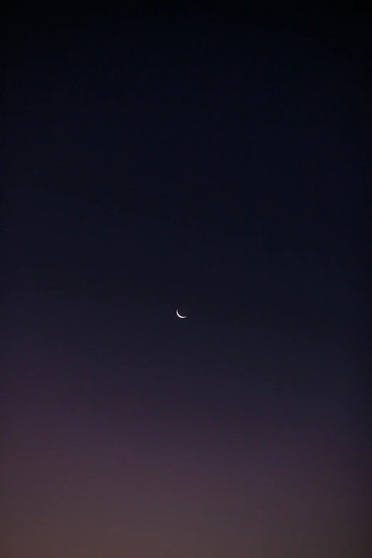 the night sky with a partial moon and venus in the distance