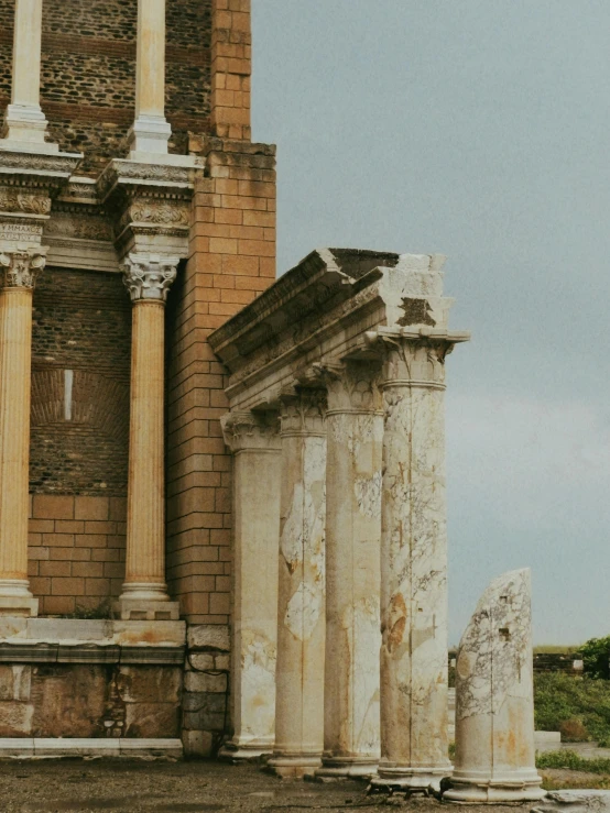 some very old looking columns in front of a brick building